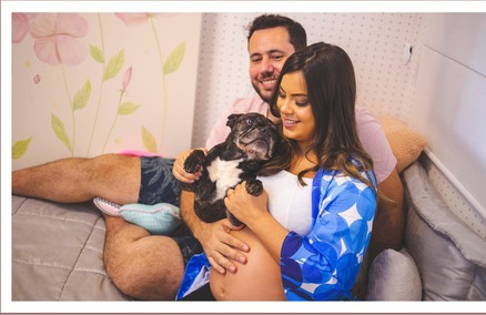 Casal e cachorro reunidos durante o ensaio de gestante